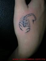 Tatuaje de un pequeño escorpión en la mano