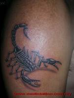 Tatuaje de un escorpión con la palabra Que en las pinzas