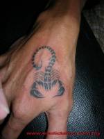 Tatuaje de un escorpión tribal en la mano