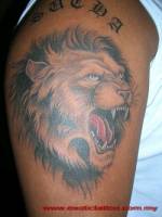 Tatuaje de un león rugiendo con unas letras góticas encima
