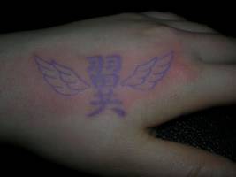 Tattoo de un kanji con alas con tinta ultravioleta