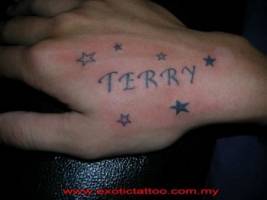 Tatuaje de un nombre en la mano con algunas estrellas