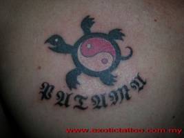 Tatuaje de una tortuga con el yin yang y un nombre