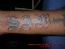 Tattoo de un nombre con una cruz