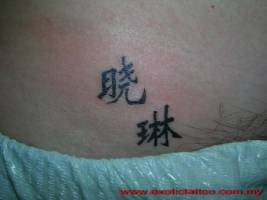 Tatuaje de letras chinas cerca del pubis