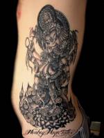 Tatuaje de Ganesha el dios hindú bailando encima de una flor de loto
