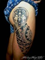 Tatuaje de una cara maori en el culo y la pierna