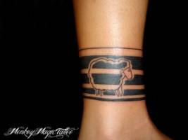 Tatuaje de un brazalete con una oveja en el tovillo