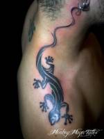 Tatuaje de una sombra de salamandra bajando por el cuello y hombro