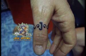 Tatuaje de un anillo tribal en el dedo pulgar