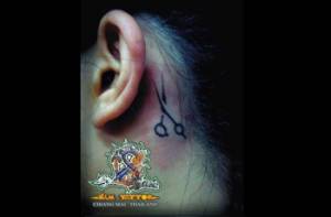 Tatuaje de unas tijeras detrás de la oreja