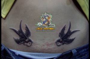 Tatuaje de dos golondrinas en la barriga