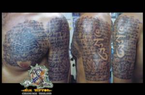 Tatuaje de un muro en el brazo con estatuas y letras 