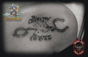 Tatuaje de unas cadenas rotas con unas letras tailandesas
