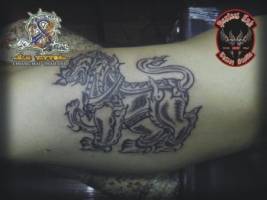 Tatuaje de un león tailandés en el brazo