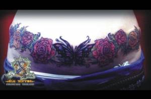 Tatuaje de un cinturón de rosas con una mariposa en medio