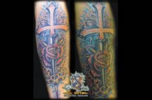 Tatuaje de una espada con forma de cruz atravesando una rosa y un puño americano