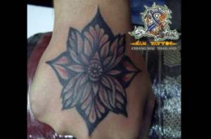 Tatuaje de una flor en la mano