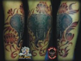 Tatuaje de un elefante entre sombras de flores