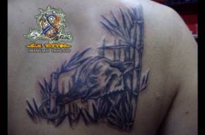 Tattoo en la espalda de un elefante comiendo bambú