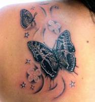 Tatuaje de unas mariposas volando bajo las estrellas y algunas flores