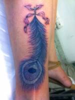 Tatuaje de una pluma de pavo real atada dentro de la pierna
