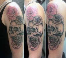 Tatuaje en el brazo de una calavera con tres rosas