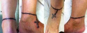 Tatuaje en el pie de un brazalete con una cruz colgando