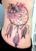Tatuaje de un atrapasueños con algunas flores