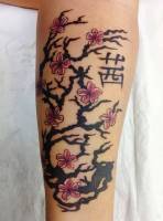 Tatuaje de un árbol florecido con una letra china