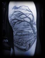 Tatuaje de un descapotable bajo un árbol sin hojas