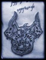 Tatuaje del logo del tatuador con unas máquinas de tatuar en forma de calavera