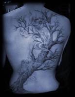 Tatuaje de un árbol con espíritus rondando