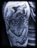 Tattoo de una mano sujetando un corazón