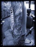 Tatuaje de manga entera. Calaveras y carpas. Detalle del codo