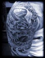 Tatuaje de un dragón con un bola en la mano