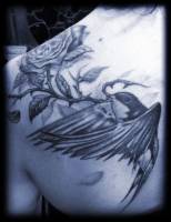Tattoo de un pájaro portando una rosa con una calavera dentro