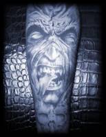 Tatuaje de un monstruo de lengua bifida y una calavera