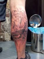 Tatuaje en la pierna de un velero en blanco y negro