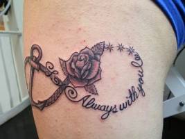 Tatuaje de un ancla , un a cuerda , una rosa y ua frase formando el simbolo del infinito