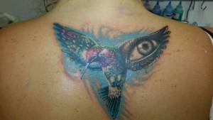 Tatuaje de un pájaro con un ojo en las alas