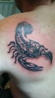 Tatuaje de un escorpión en blanco y negro en la espalda de un hombre