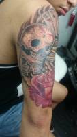 Tatuaje de una calavera mexicana con unos dados, cartas y rosa