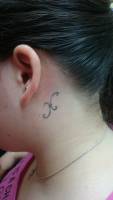 Tatuaje de una letra H detrás de la oreja