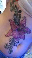 Tatuaje de una flor y unas mariposas en la barriga de una chica