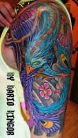 Tatuaje de un ave fénix a color en el brazo