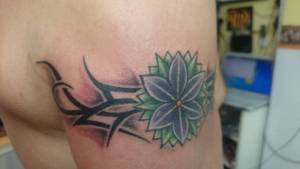 Tatuaje de un brazalete tribal con una flor