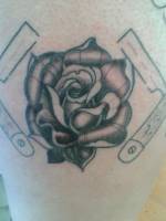 Tatuaje de una rosa rodeada de navajas de afeitar