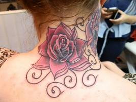 Tatuaje de grandes rosas en la nuca y cuello de una mujere