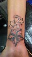 Tatuaje de estrellas de cinco puntas en el antebrazo
